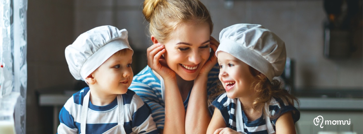 A hosting mama baking with two little ones in chef hats at her kitchen counter
