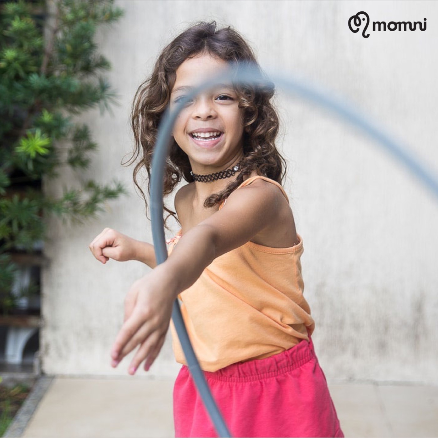 A laughing girl mid-spin with her hula hoop