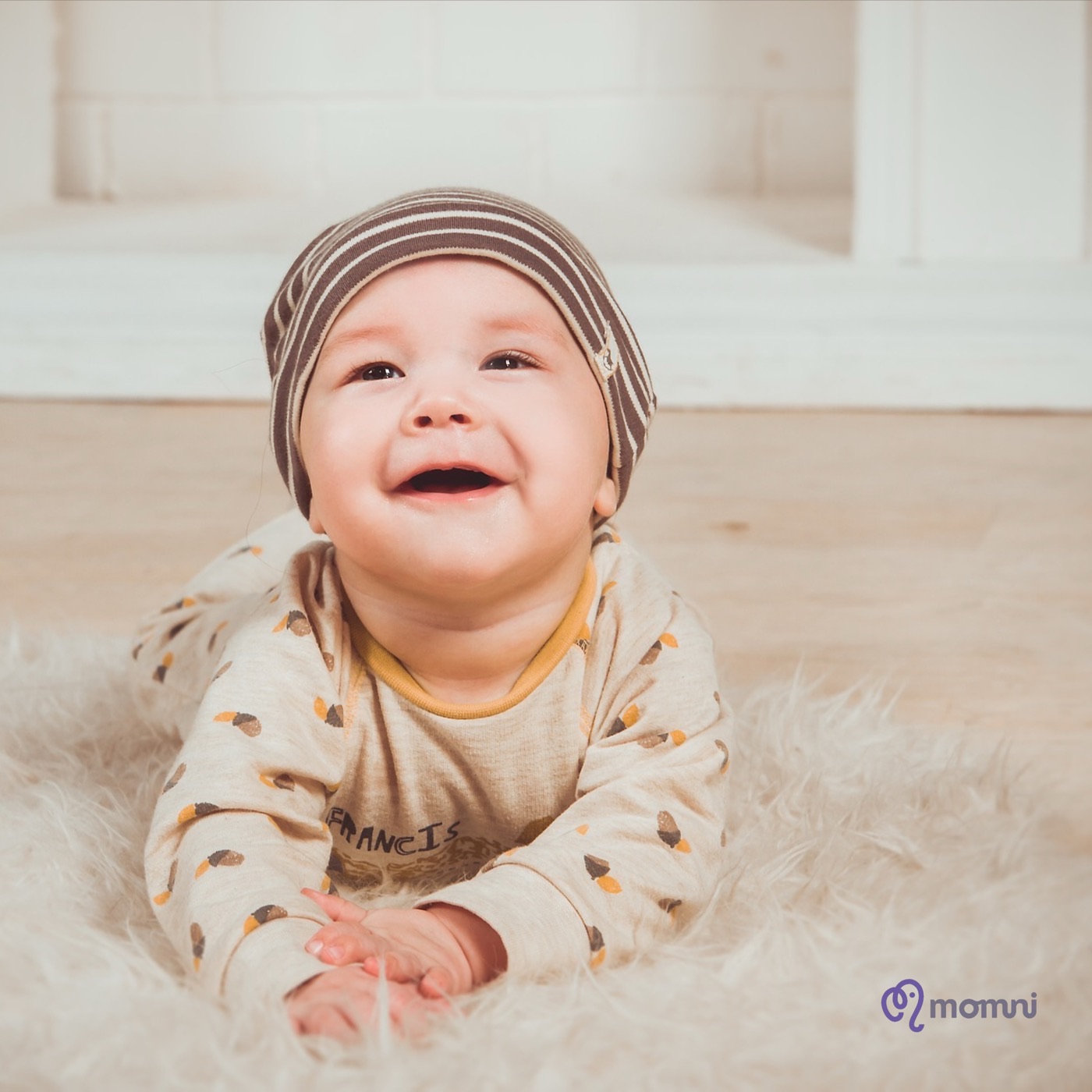 A laughing baby on a soft rug
